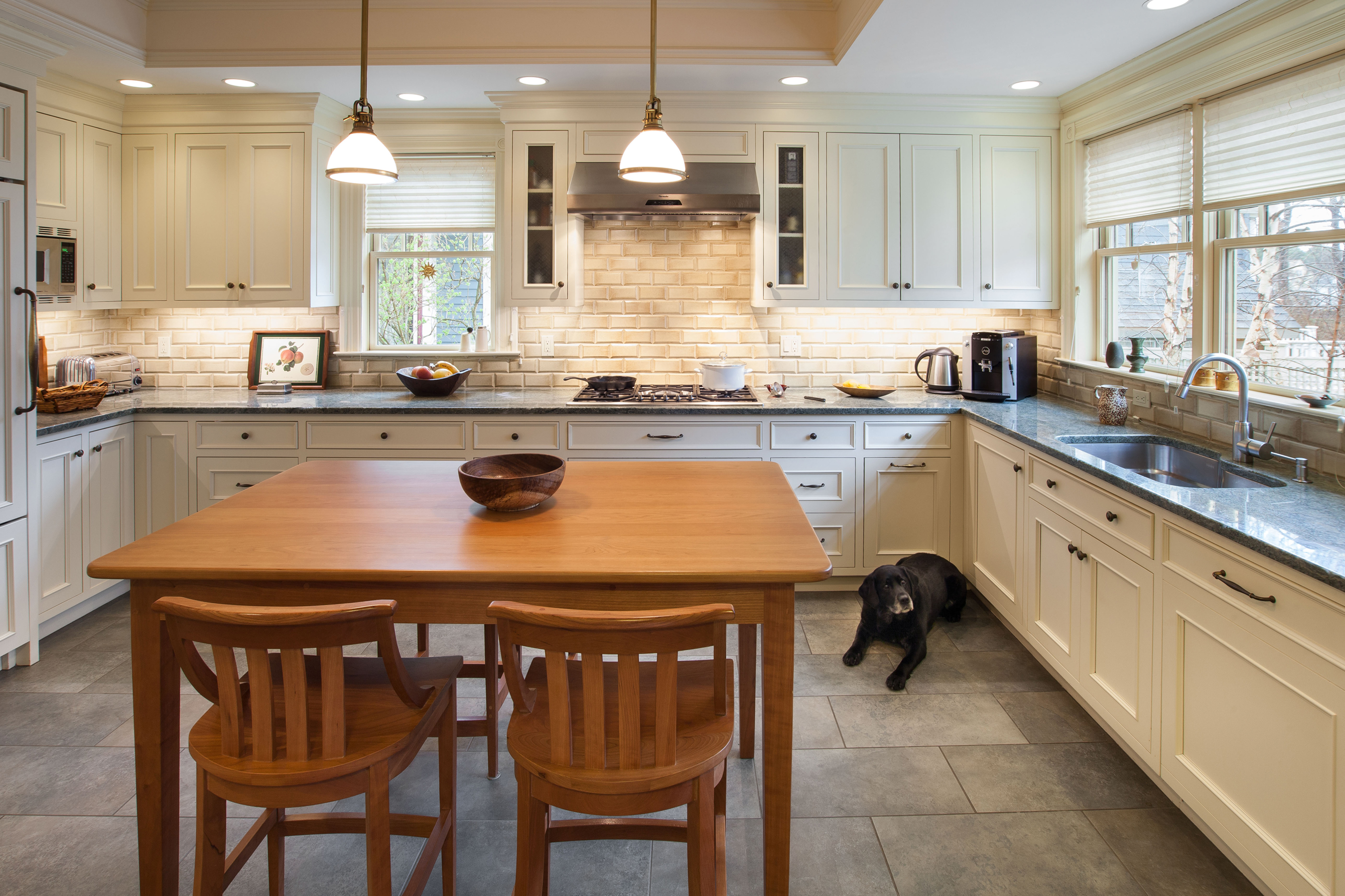 A finished kitchen with white cabinets, a gas cooktop and windows over the counter, plumbed by Pipelines